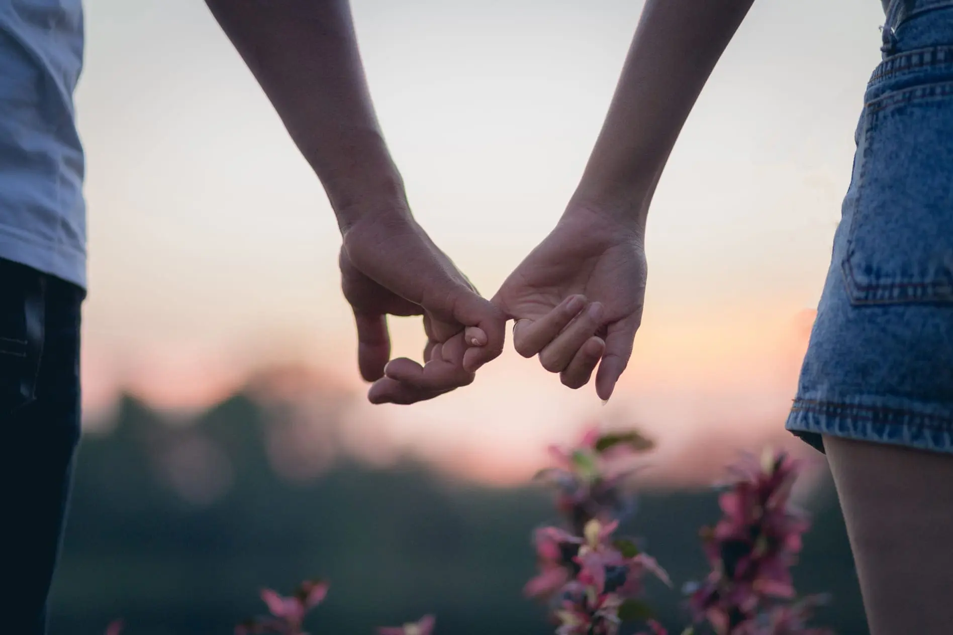 casal com imagem destacando suas mãos entrelaçadas.